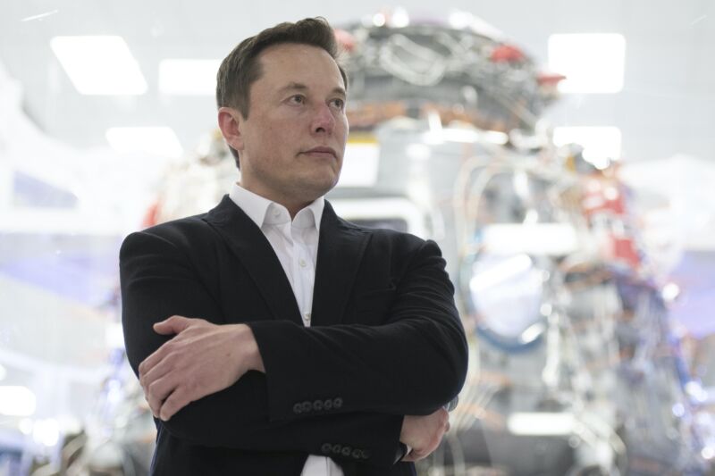 El CEO de SpaceX, Elon Musk, de pie con los brazos cruzados.