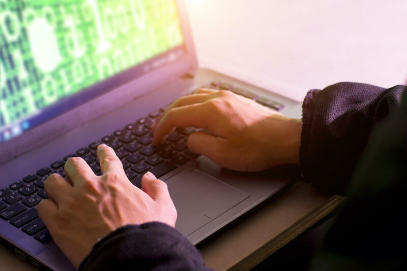 Una pantalla de computadora portátil llena de ilustraciones estilizadas de ciberdelincuencia.