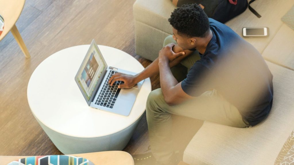 Imagen de una persona sentada cómodamente con una computadora portátil.