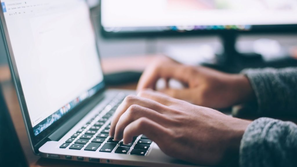 Imagen de una persona escribiendo en una laptop.