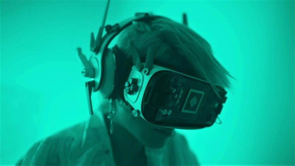 Imagen de una persona que usa un conjunto de realidad virtual muy modificado bajo luz verde.