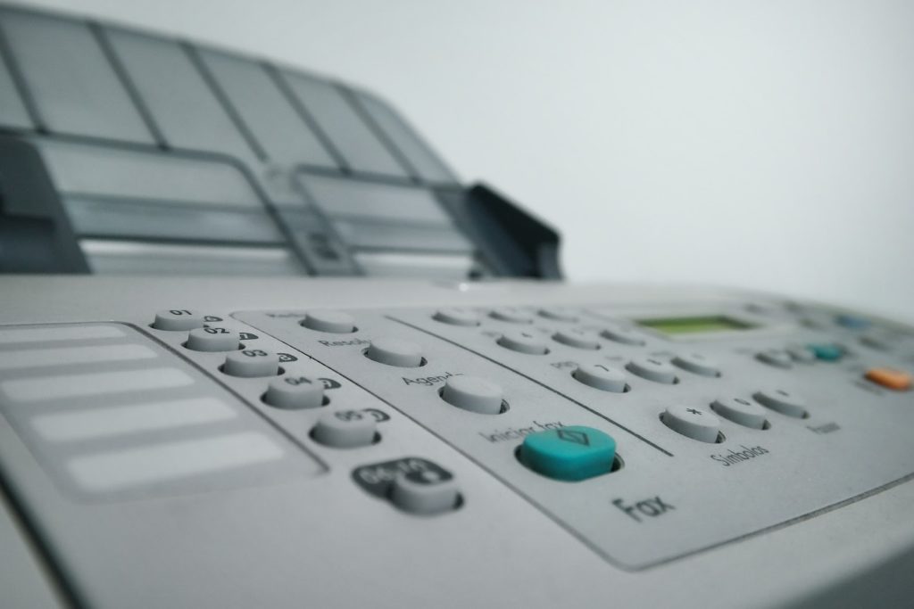 Imagen de una máquina con la palabra fax debajo de un botón verde.