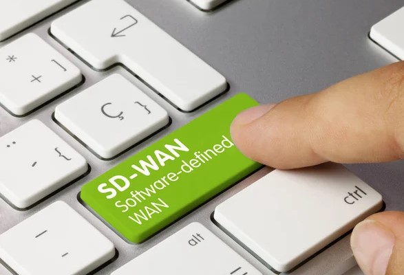 Imagen de un teclado con un dedo presionando una tecla SD-WAN verde.