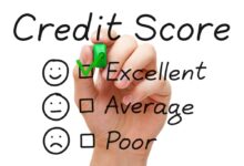 Hand putting check mark with green marker on excellent credit score evaluation form.