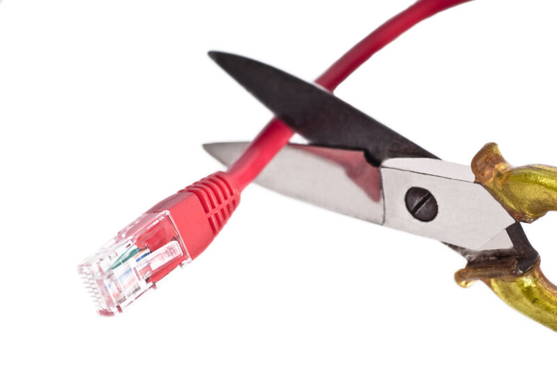 Un par de tijeras cortando un cable Ethernet.