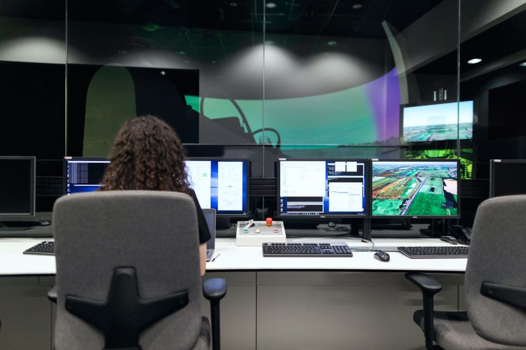 Una mujer se sienta frente a una computadora en un centro de comando, protegiéndose contra las amenazas de seguridad.