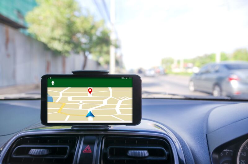 Un teléfono celular muestra un mapa y direcciones mientras está montado en el tablero de un automóvil.