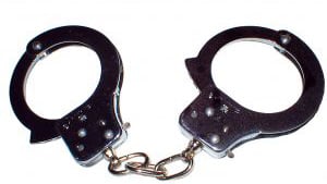Stock photo of police handcuffs against white background.