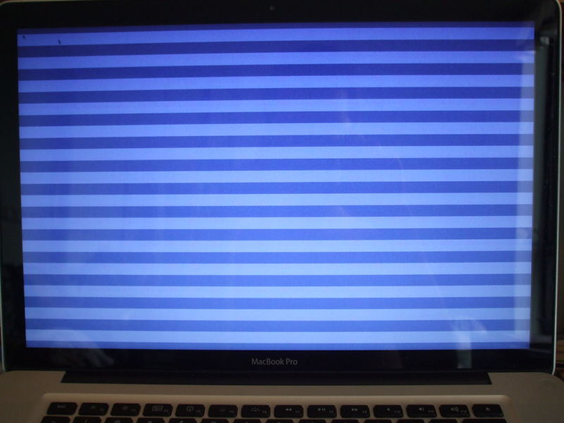 Foto de una MacBook con una pantalla azul rayada, lo que indica problemas graves.
