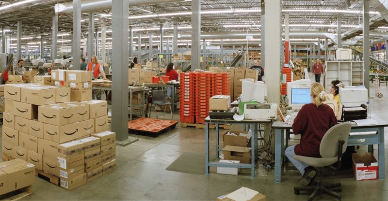 Trabajadores y paquetes dentro de un almacén de Amazon.